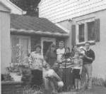 Black 和 White photo of 波斯尼亚 family outside a home.